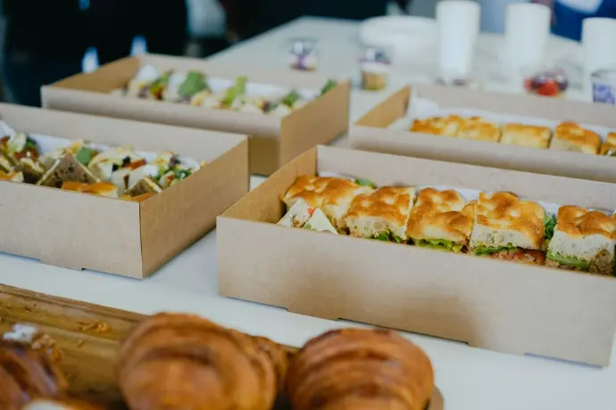 a table topped with boxes of sandwiches and pastries